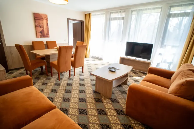 Deluxe szoba nappalija televízióval és kanapéval